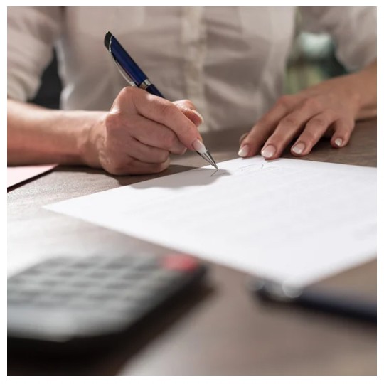 Person signing a deed poll document to legally change their name.